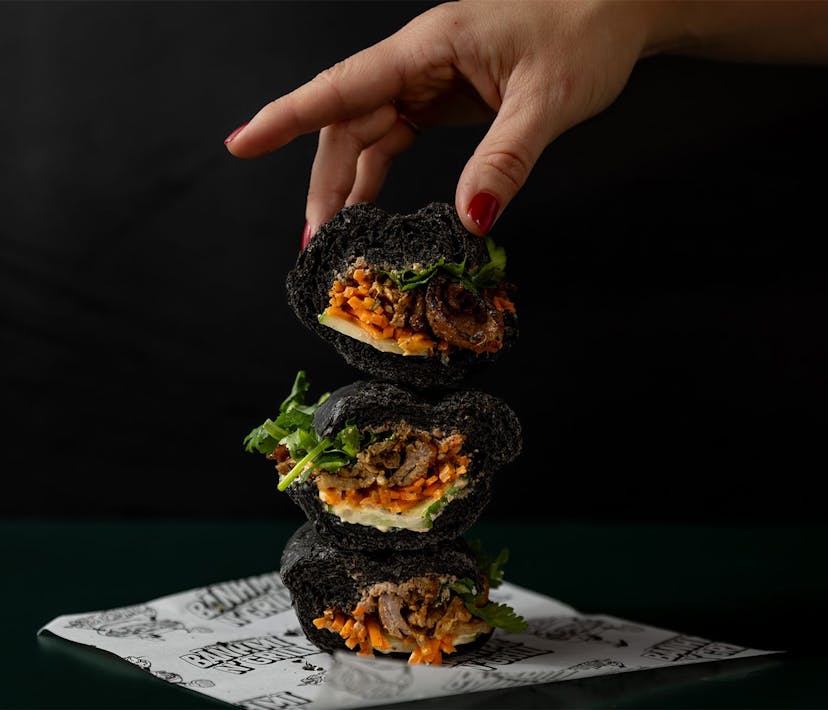 Three stacked pieces of a midnight banh mi roll.