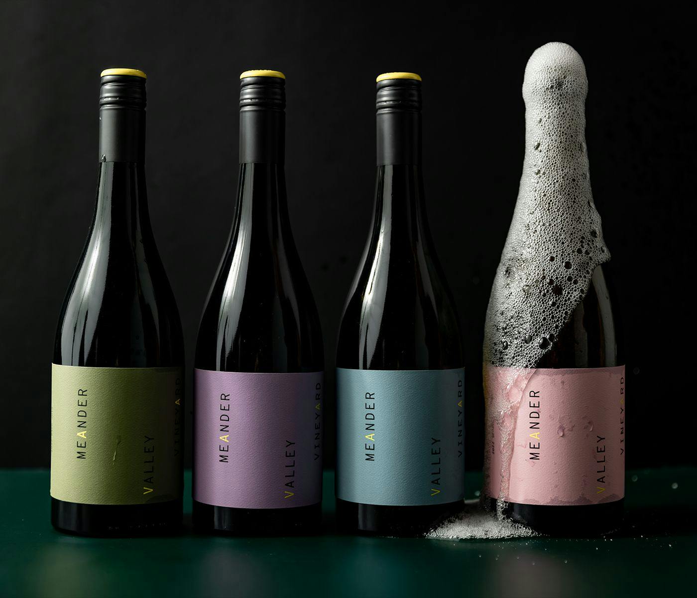 Four bottles of Meander Valley wine, the rightmost is covered in flowing bubbly wine,