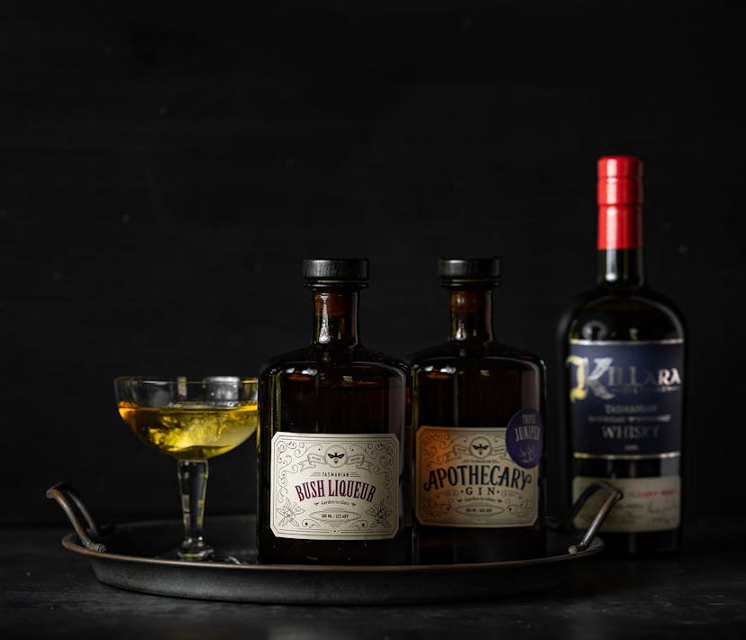 A tray of three Killara Distillery Spirits, plus a yellow drink in a cocktail glass.