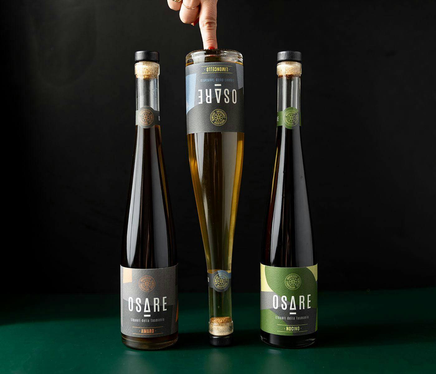 Three bottles of Osare spirits, the middle one standing up-side down.