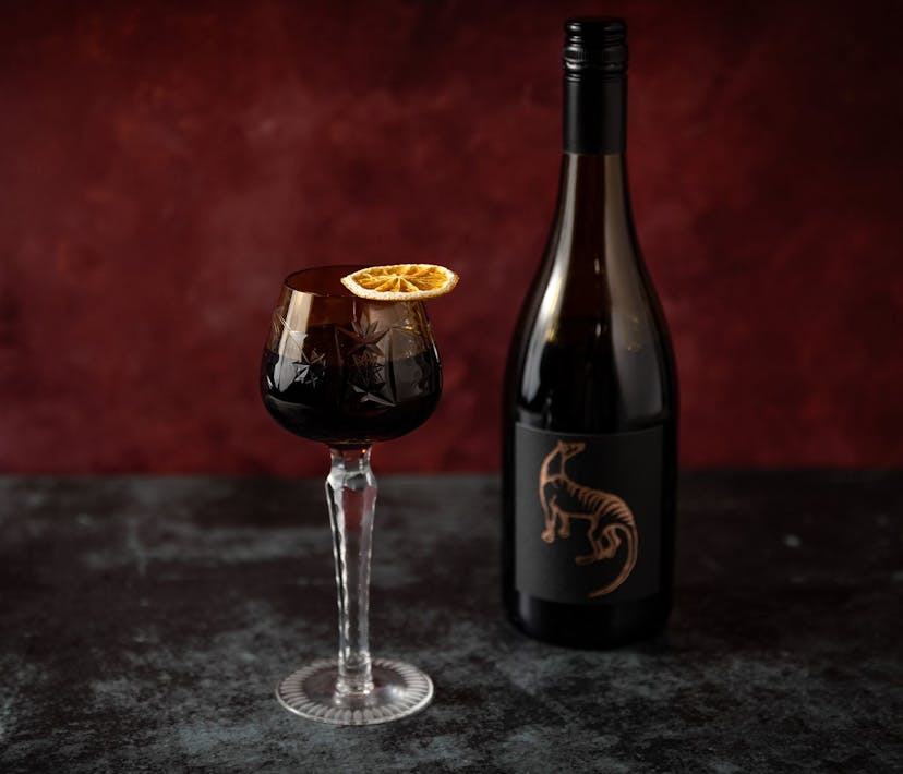 A glass of Hot Dark Red, topped with a preserved slice of citrus.