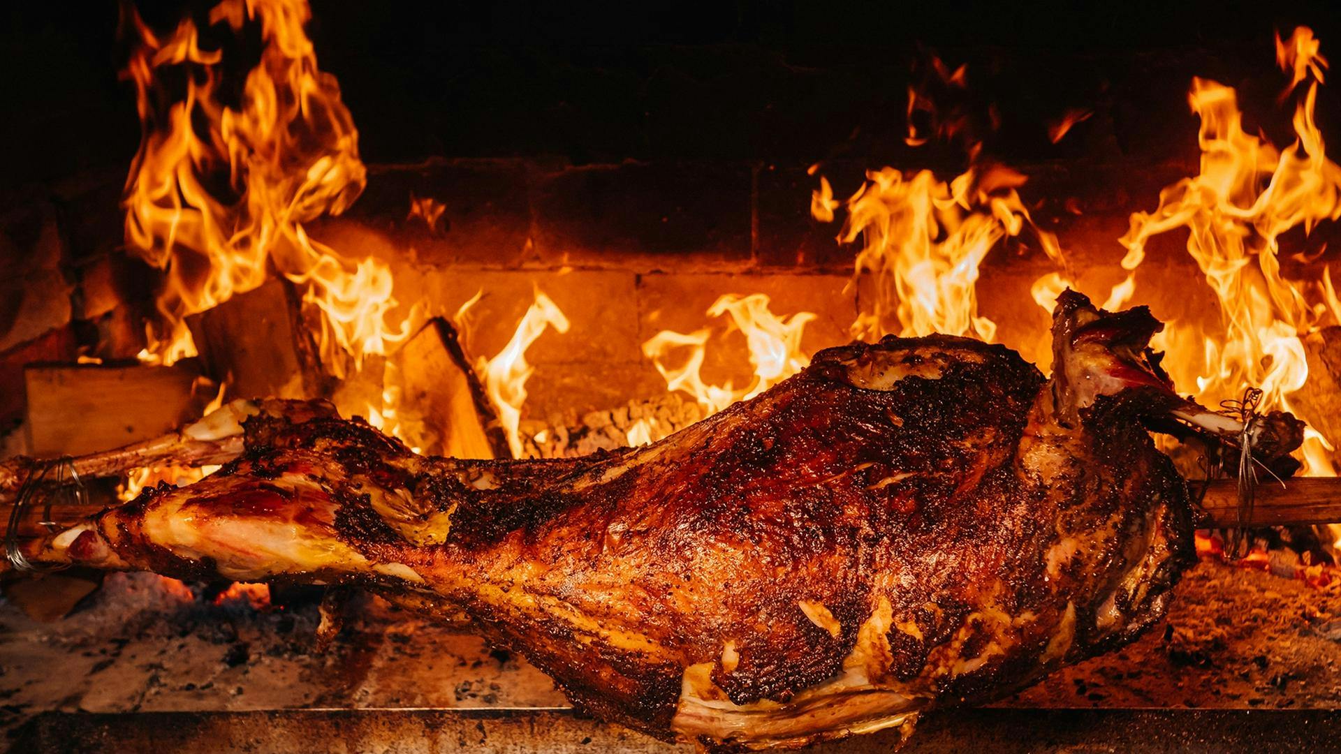 A lamb on a spit roasting over fire