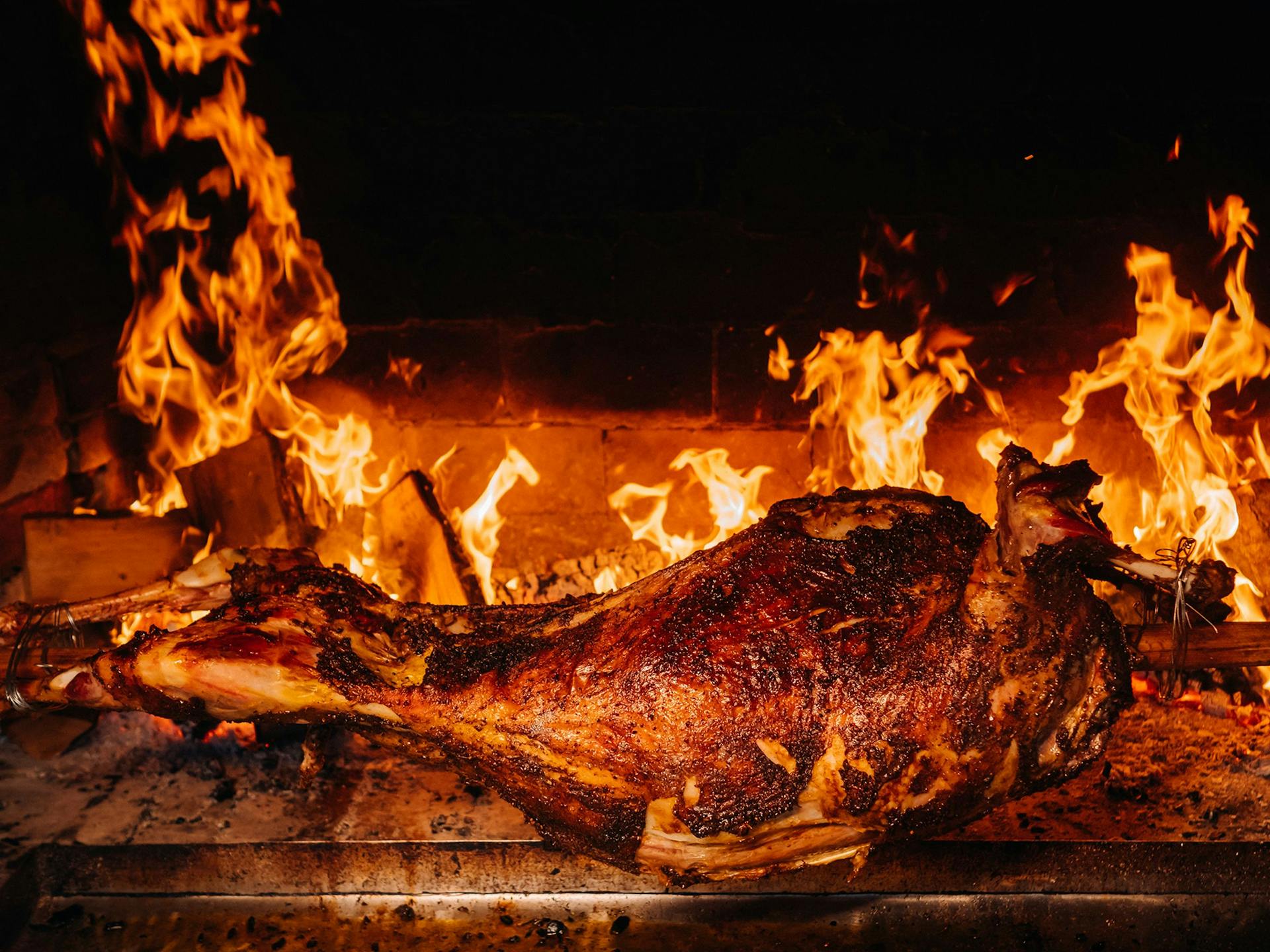 A lamb on a spit roasting over fire