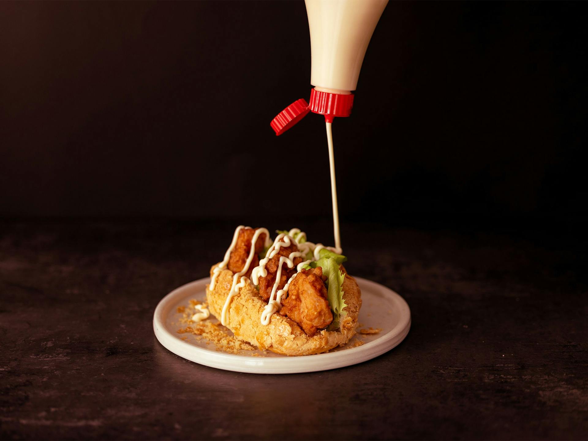 Kewpie Mayo drizzling atop a deep-fried Taiwanese sandwich