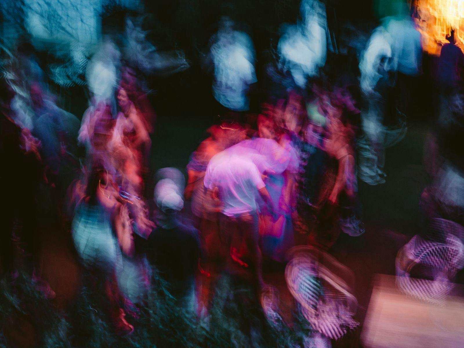 A highly blurred purple and blue image of a crowd of people.