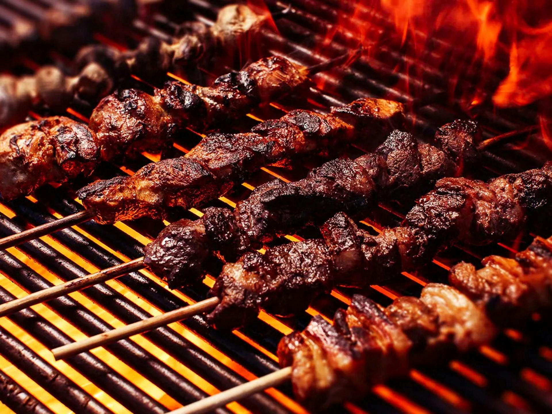 Meat sticks on a grill with fire