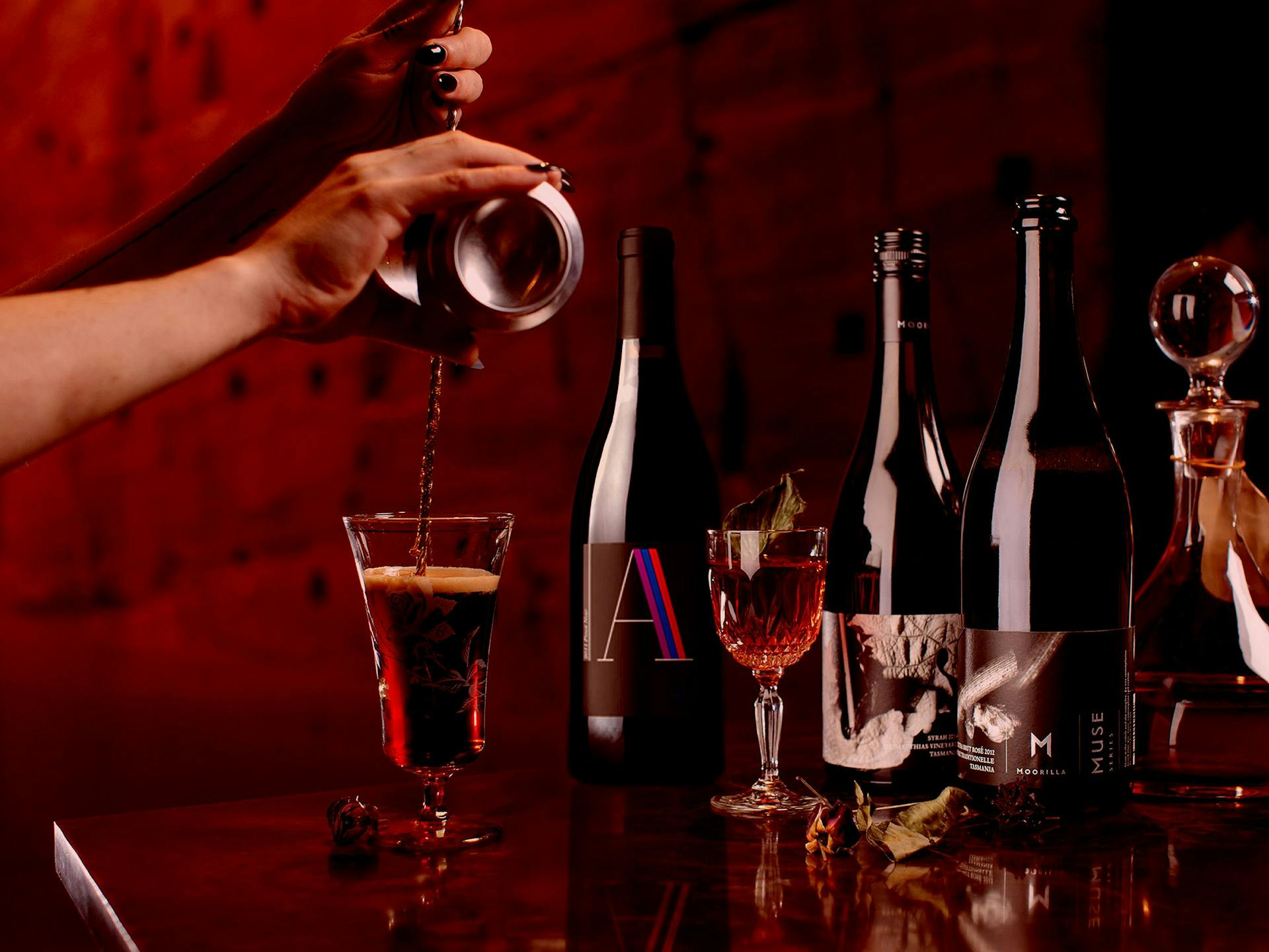 A selection of wine and cocktails against a deep red background