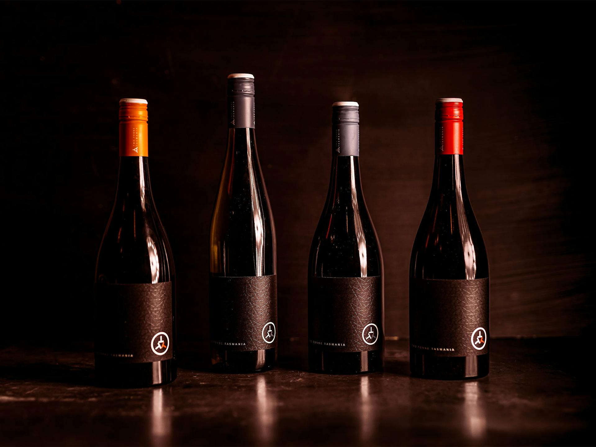Four bottles of wine against a dark backdrop