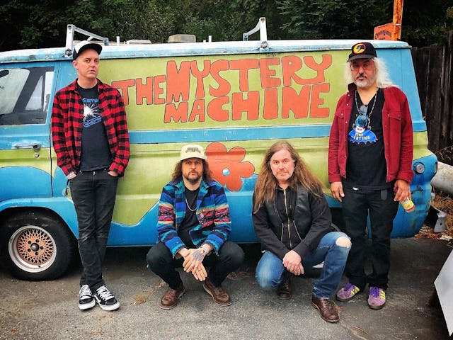Members of Witch pose in-front of a replica 'The Mystery Machine' van.