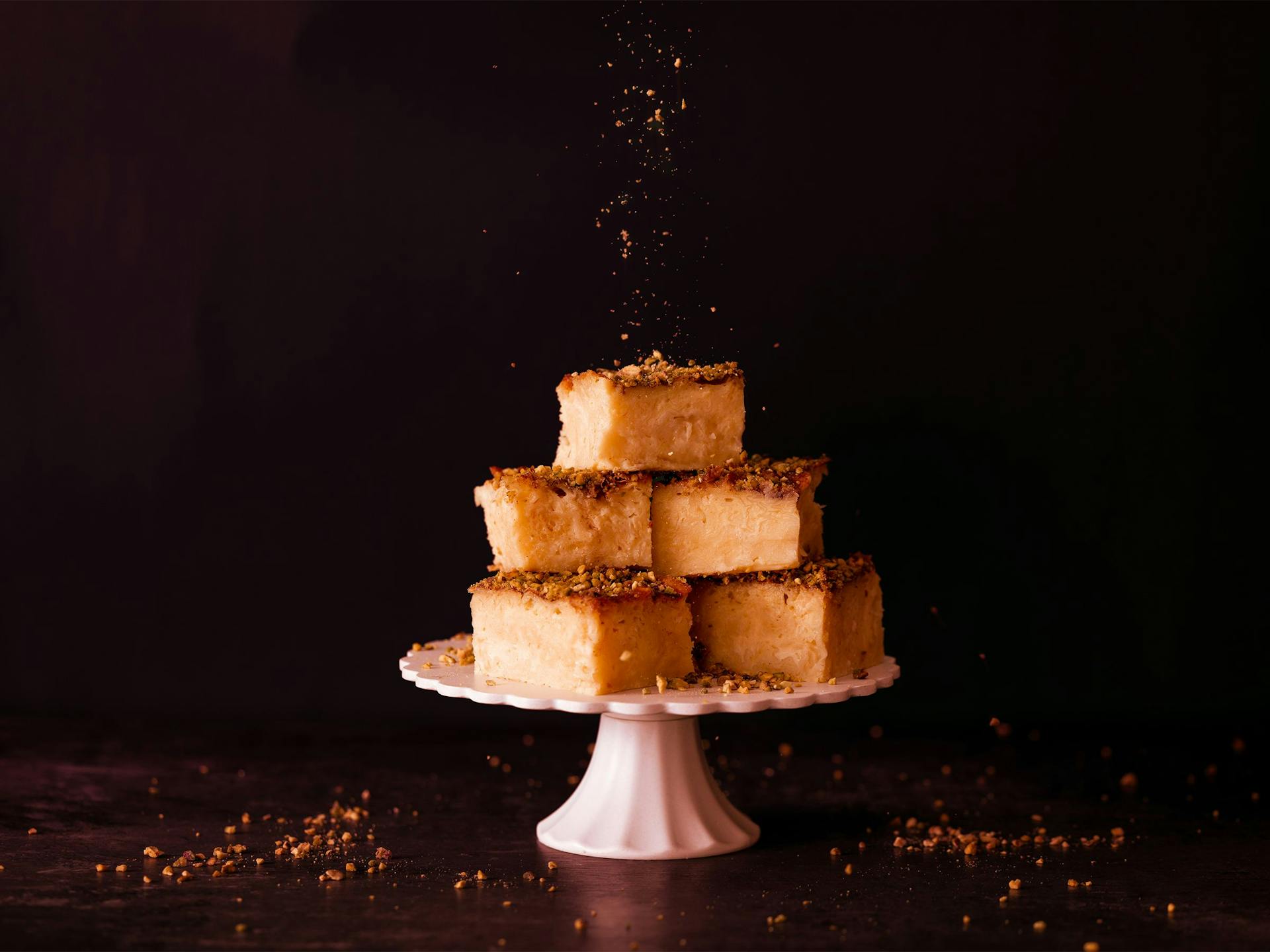 Soufra piled up on an elegant cake stand are sprinkled by chopped pistachios