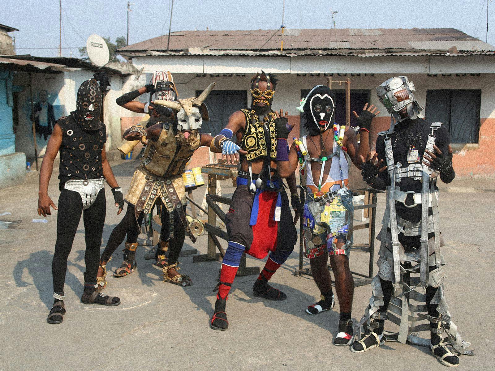 The 6 Members of Fulu Miziki pose wearing home-made costumes and masks.