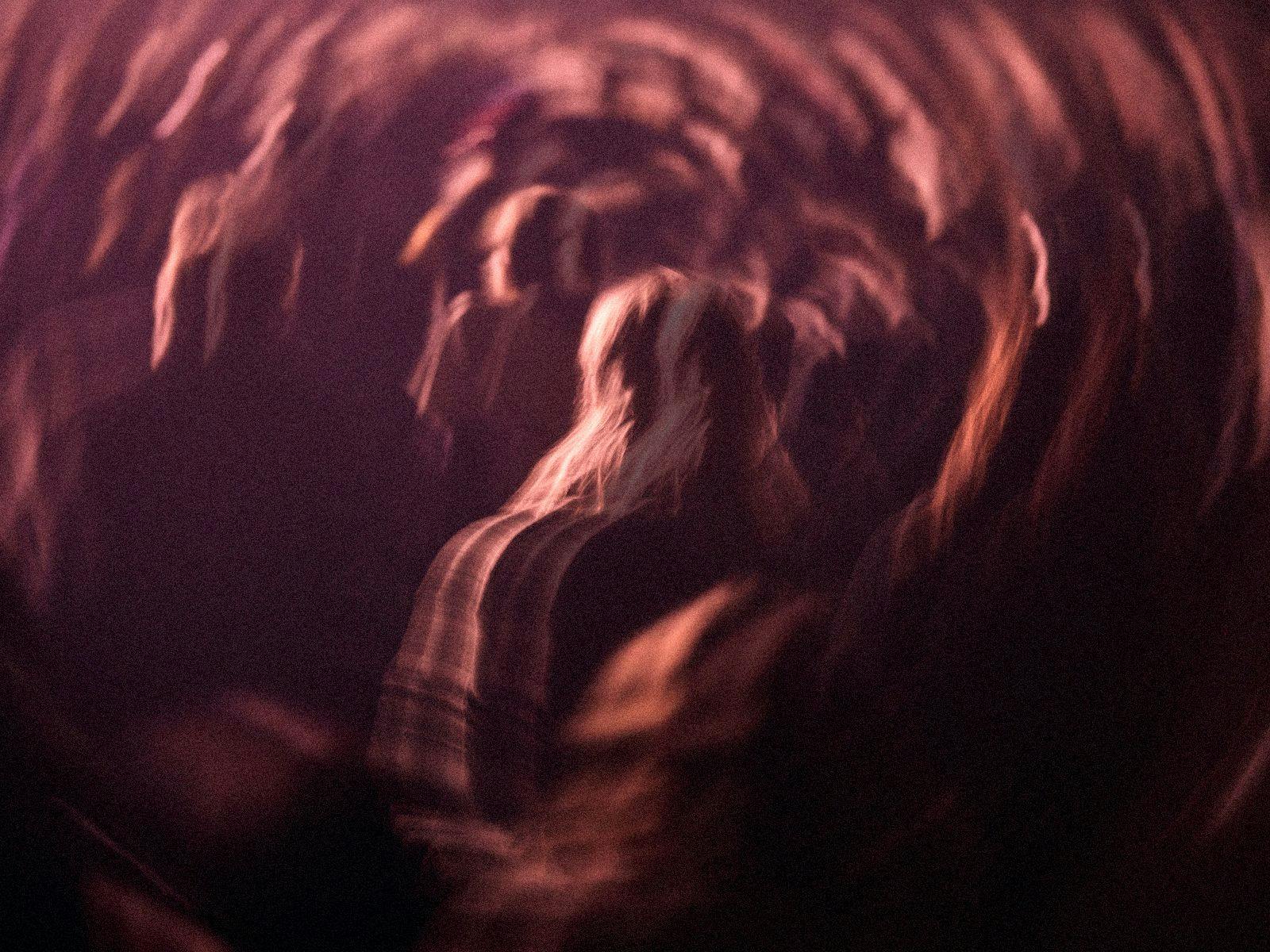 A blurred and warped image of several people standing in a crowd.